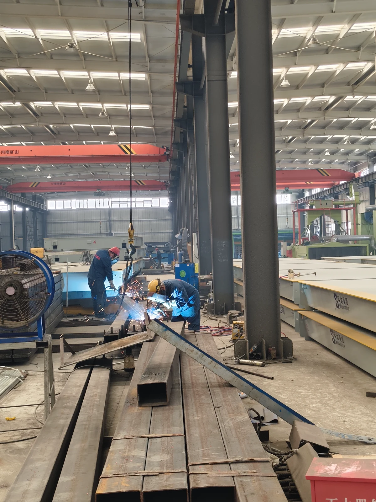 Workers welding steel structures in the SHIDA GROUP workshop